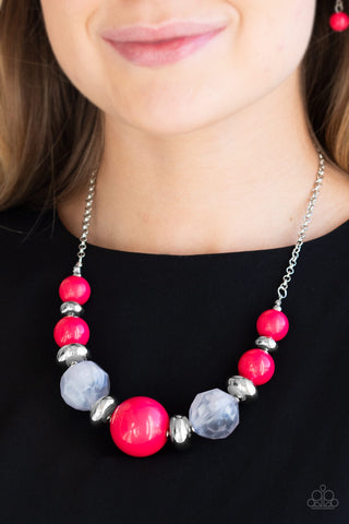 A necklace with hot pink beads, silver beads, and cloudy beads increasing in size towards the center.